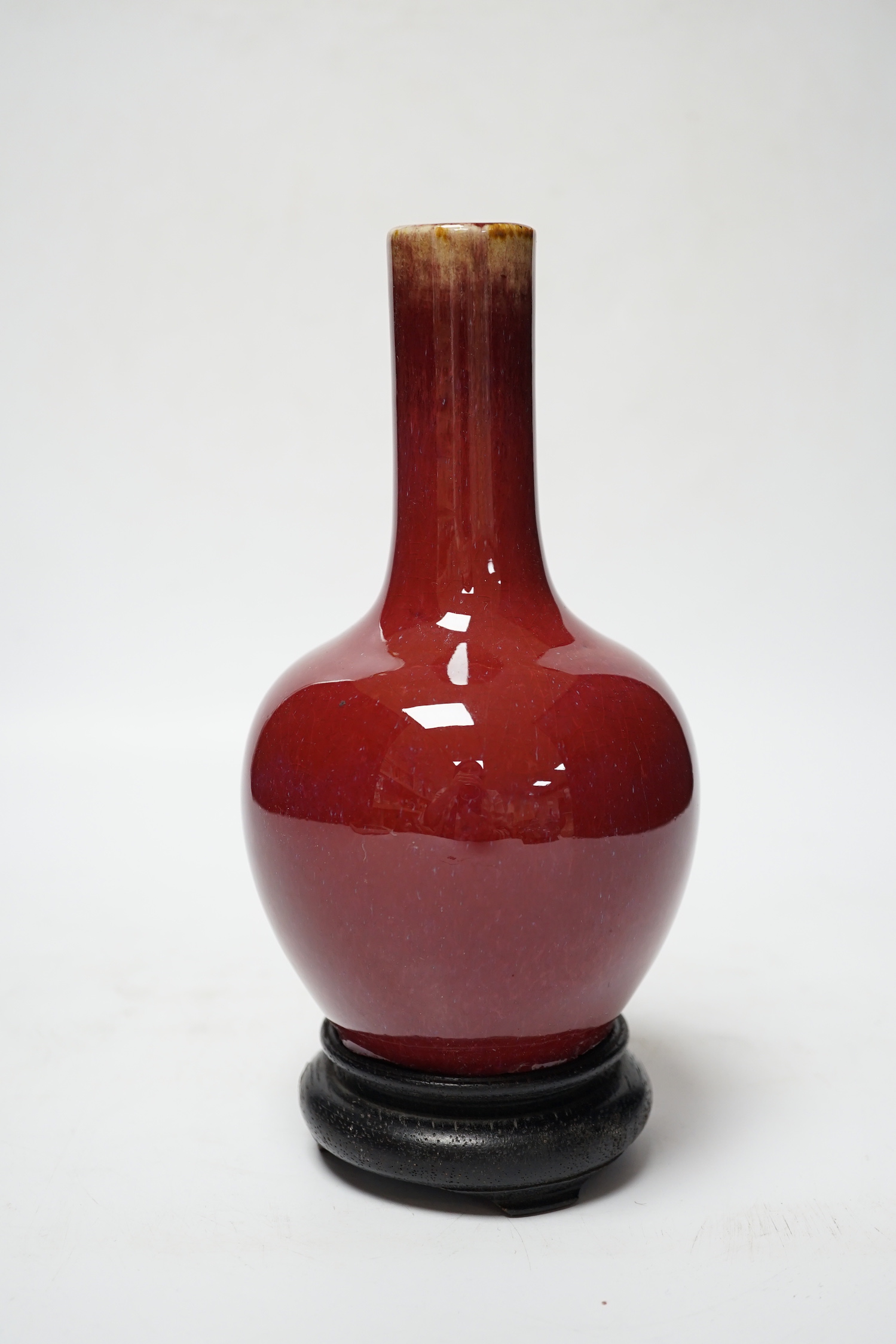 A small Chinese sang de boeuf glazed vase and stand 22cm high including stand